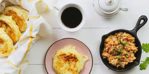 Cómo hacer arepas rellenas de queso acompañadas de huevos perico. Quizás uno de los desayunos más famosos de Colombia y Venezuela. Paso a paso con fotos y consejos.