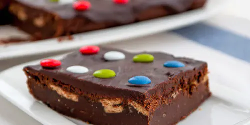 Cómo preparar un brownie de chocolate con galletas y Lacasitos. Receta fácil para fiestas de cumpleaños, perfecta para que los más pequeños cocinen.