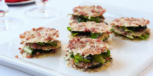 Riquísimos aperitivos navideños en forma de crujientes de parmesano y jamón con tapenade. Sorprende a tus invitados con esta receta sencilla y deliciosa que gustará a todos.