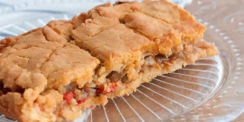 Cómo hacer una empanada gallega de berberechos. Receta de empanada con masa de maíz o millo que le dará un toque crujiente y muy sabroso. Paso a paso con vídeo.