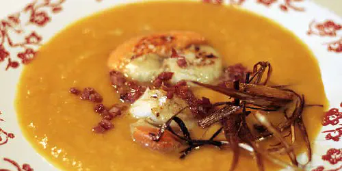 Cómo preparar una crema de otoño con aire de Navidad. Una textura dulzona de la zanahoria y la calabaza, sabor a marisco del caldo y las vieiras.